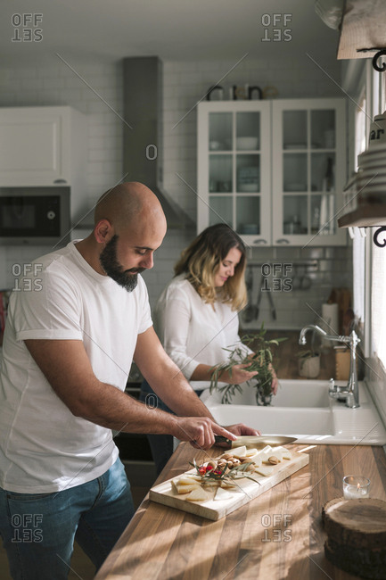 Young caucasian couple in the kitchen preparing snack table