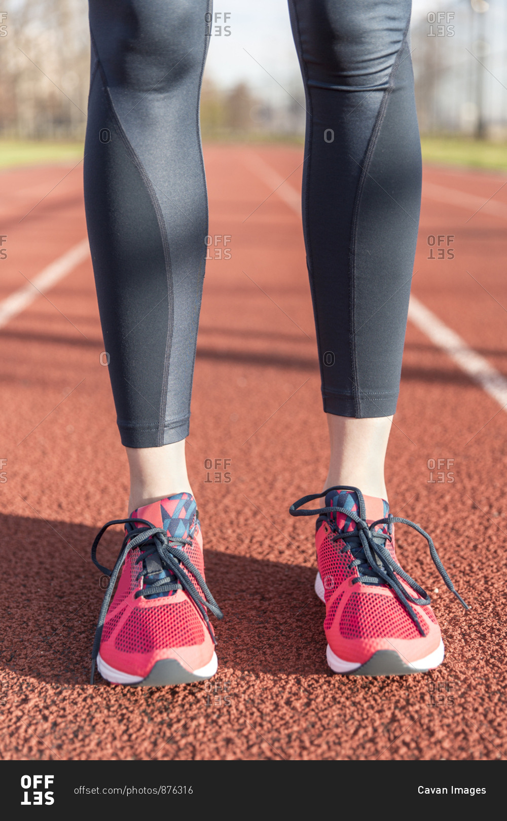 Low section of female athlete standing on sports track