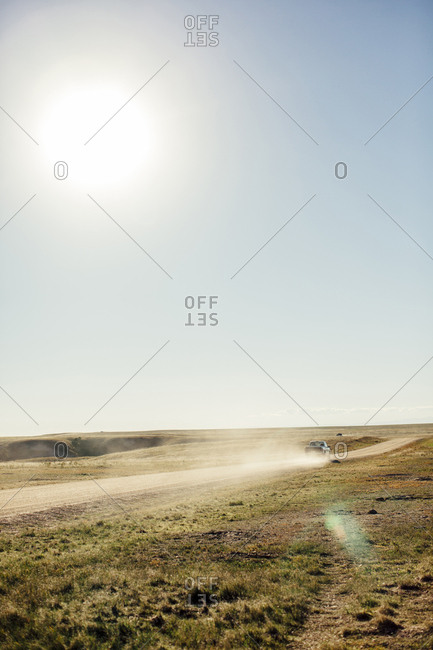 Car on dirt road against clear sky