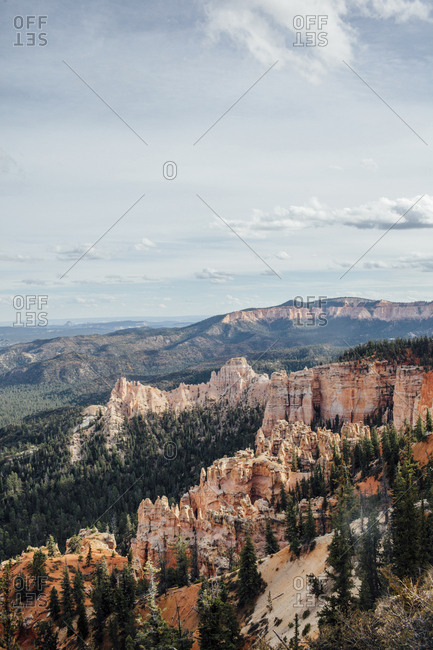 Scenic view of trees and rock formations against cloudy sky