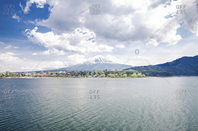 Scenic view of Mount Fuji by lake against cloudy sky