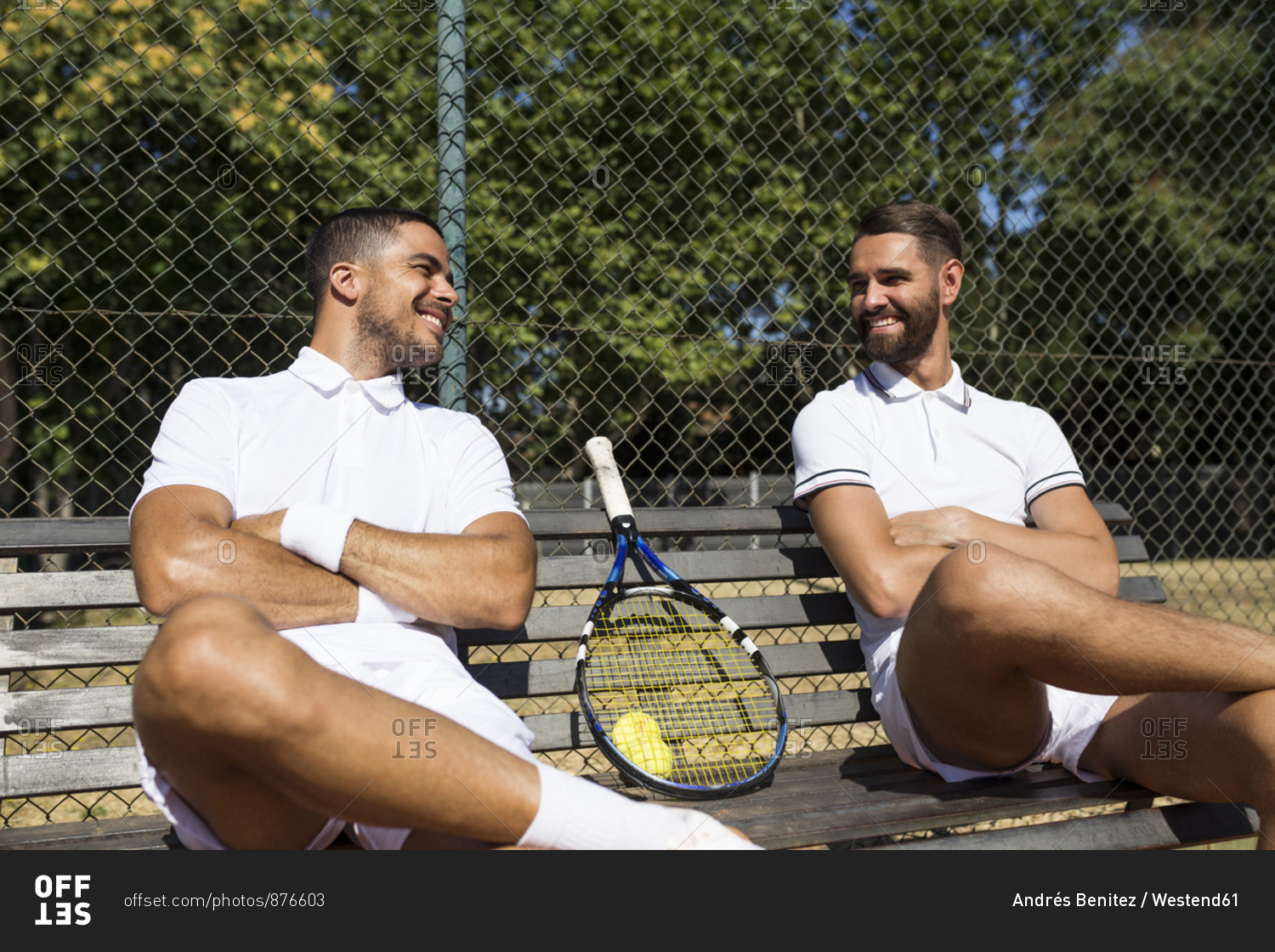 Tennis players sitting on a bench and talking during break