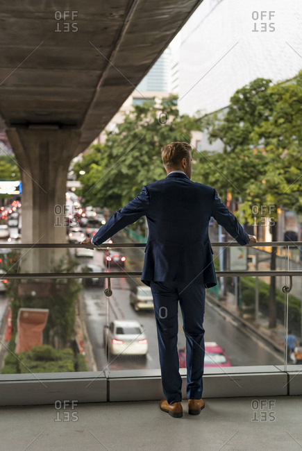 Rear view of young businessman on pedestrian bridge