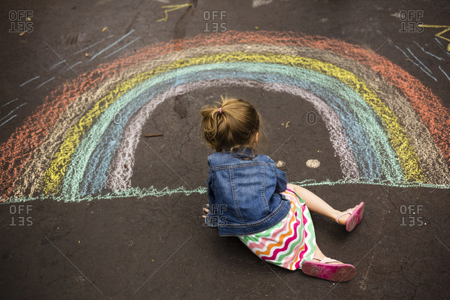 High angle view of girl drawing rainbow on asphalt