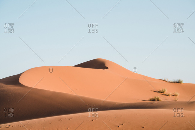 Idyllic view of sand dunes against clear sky