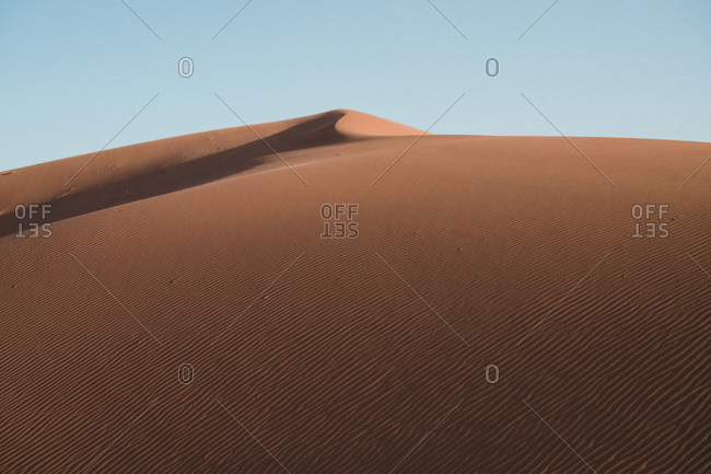 Tranquil view of sand dunes against clear sky