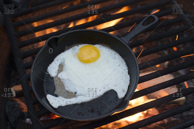 High angle view of egg in cast iron skillet on barbecue grill