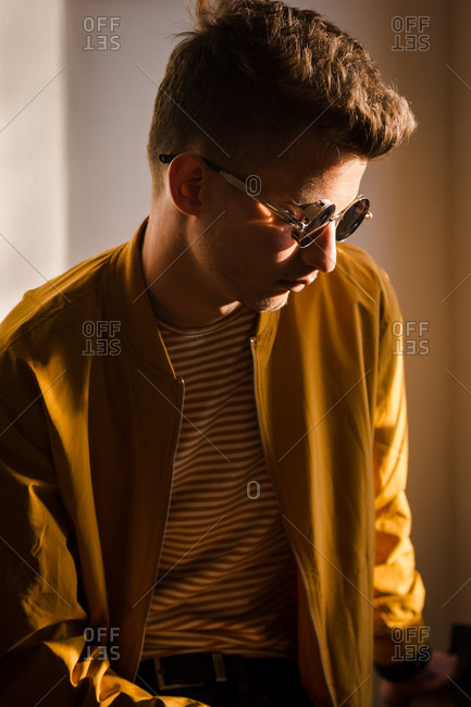 Young man with round sunglasses and  sunshine is reflected on the lens