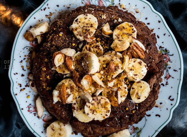 Cacao pancakes covered in banana, nuts and honey