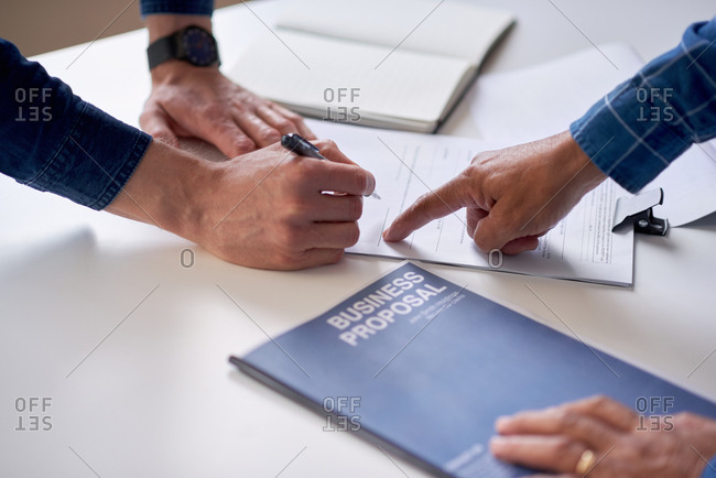 Business people hands signing contract document for corporate partnership deal