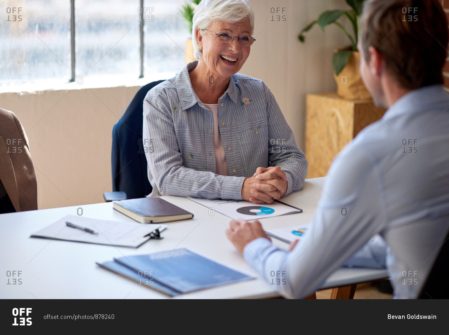 Happy old woman meeting with financial consultant discussing retirement plan