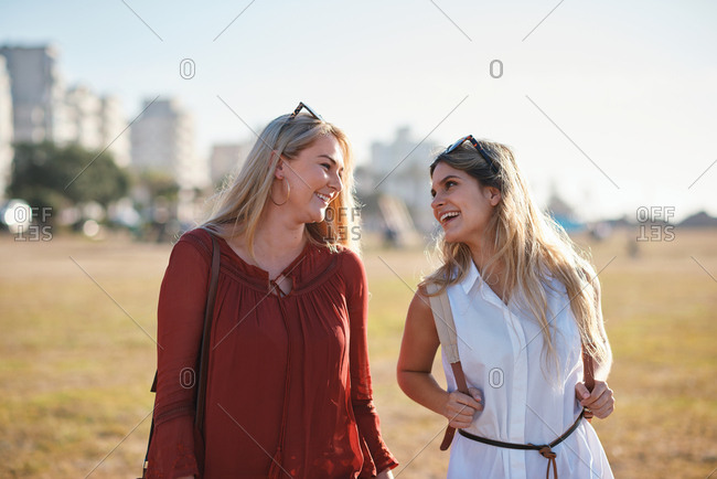 Beautiful women friends walking in park smiling happy