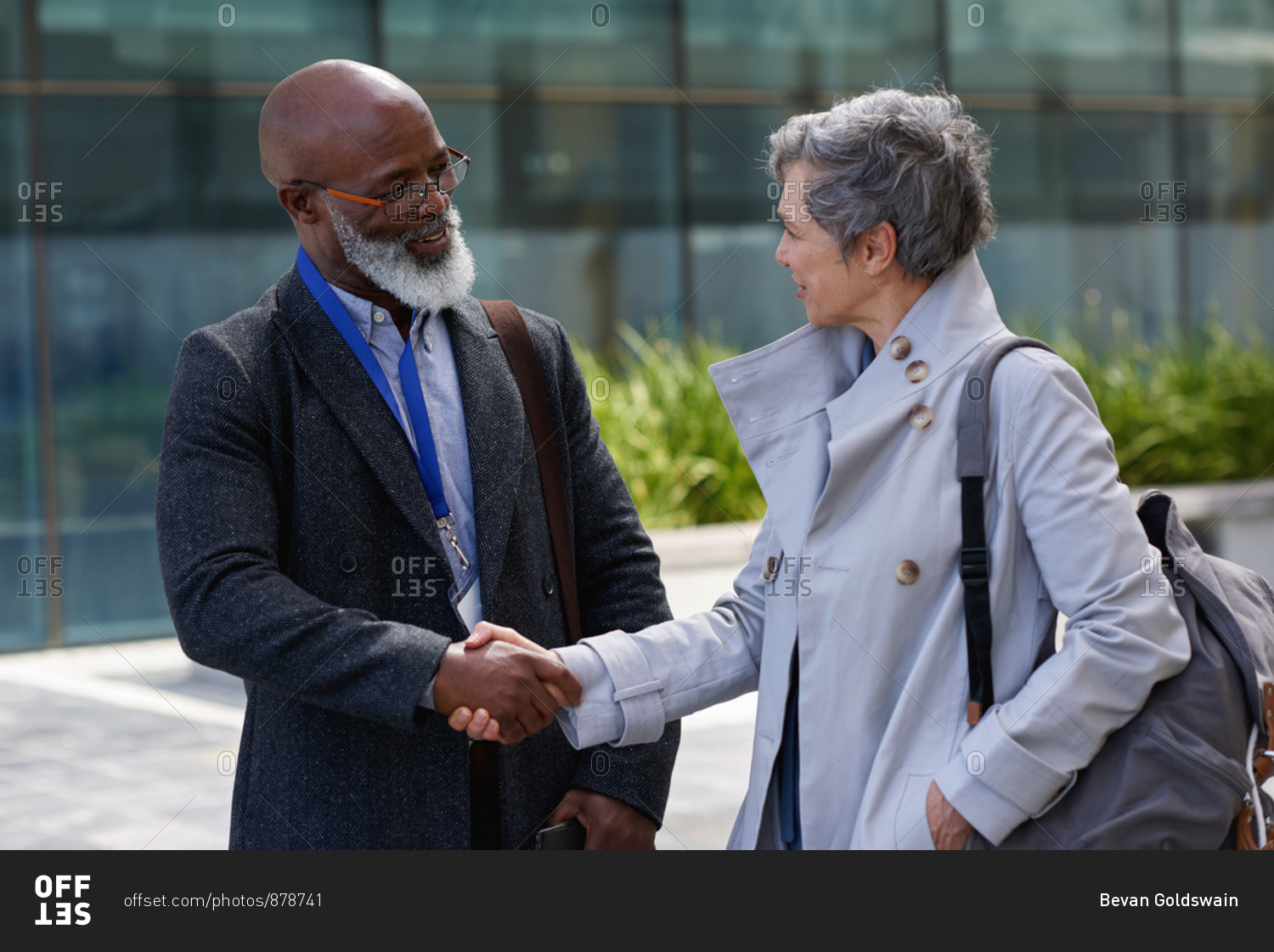 African american businessman shaking hands in city with business woman greeting client with handshake