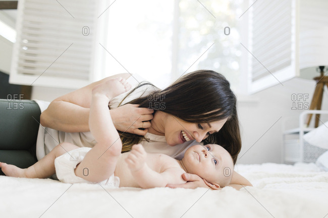 Smiling mother lying with her son on bed