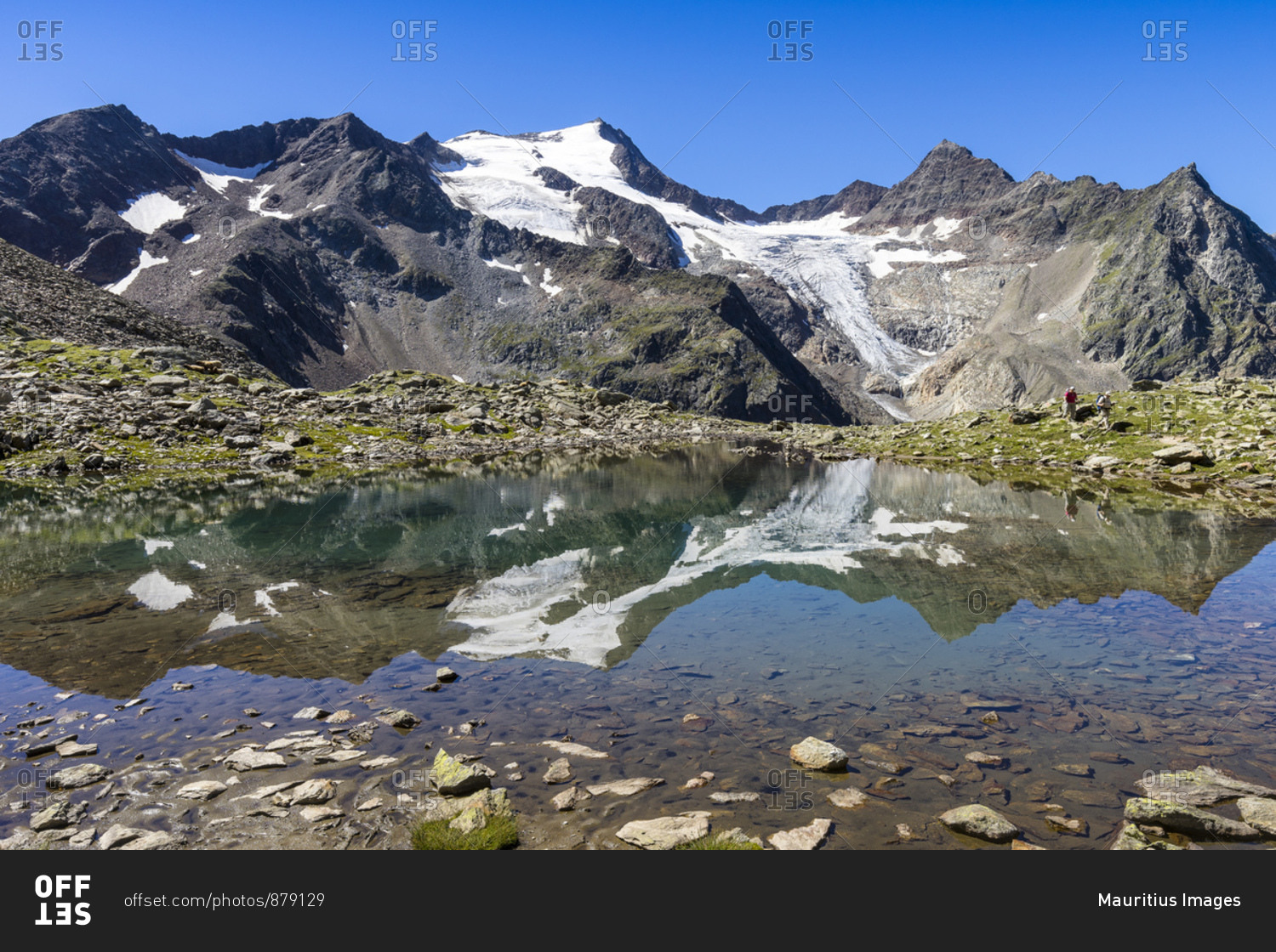 Austria, tyrol, the stubai alps, neustift, mirroring of the wilde freigers in a small lake with passing hikers
