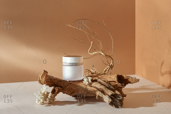 Cream container on brown background.