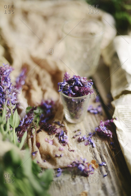 High angle view of petals in drinking glass by fabric on table