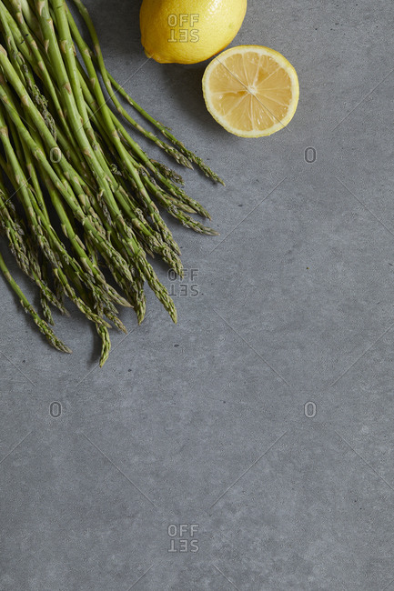 Close-up of asparagus and lemons on concrete table