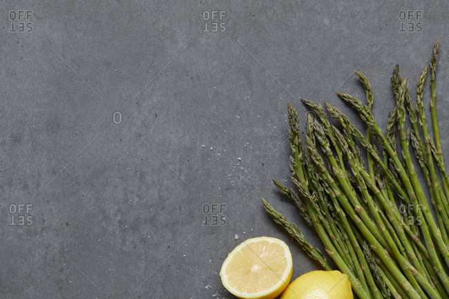 High angle view of asparagus and lemons on concrete table