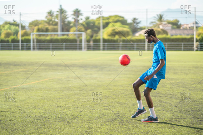 Ethnic teenager juggling football ball