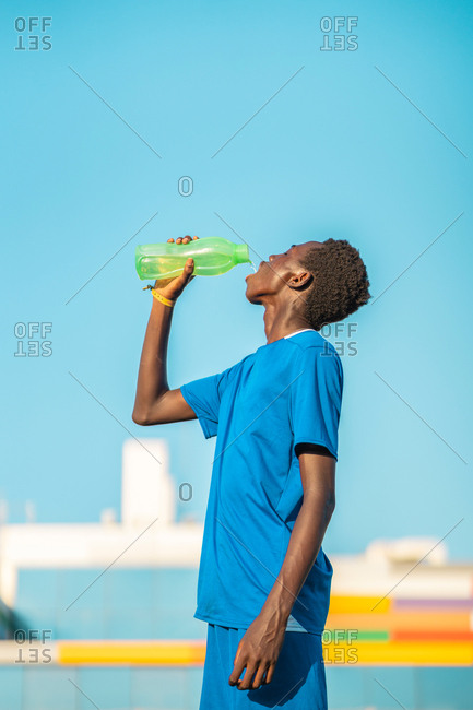 Black football player drinking water