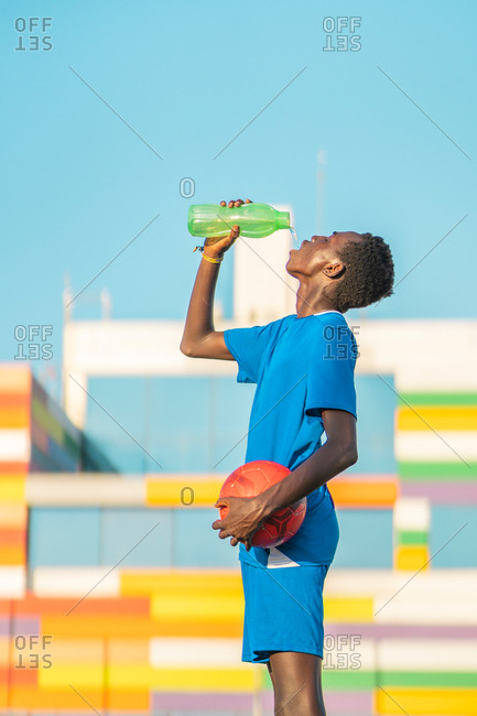 Black football player drinking water