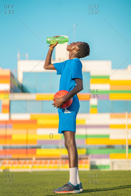 Black football player drinking water