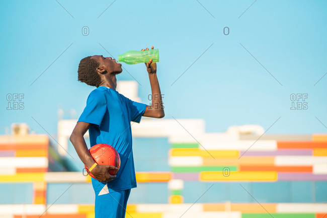 Black football player drinking water
