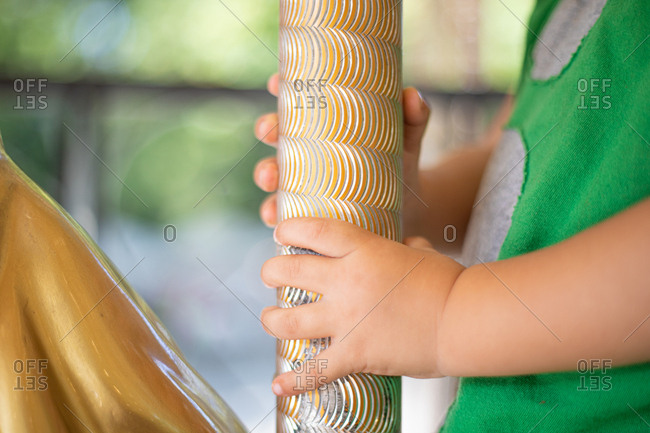 Curious little kid on colorful moving carousel at fair