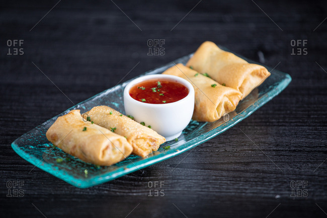 Egg rolls and dipping sauce on a clear plate