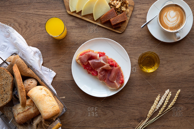 From above of tasty Spanish toast with tomato and bacon for breakfast on wooden table