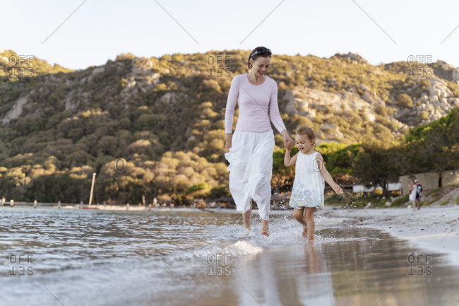 Happy mother with daughter walking at the seafront