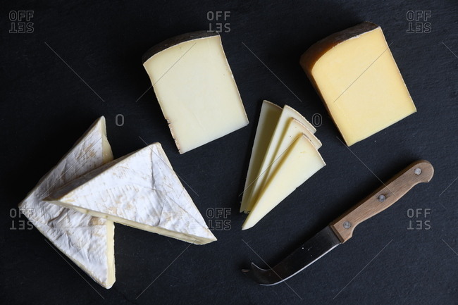 Variety of cheeses on black background with knife