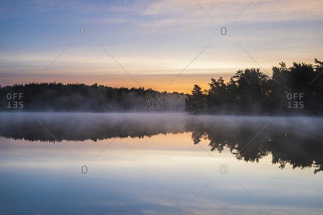 View of foggy lake at sunset