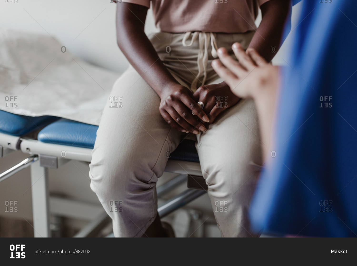 Midsection of female healthcare worker explaining to young patient in medical clinic