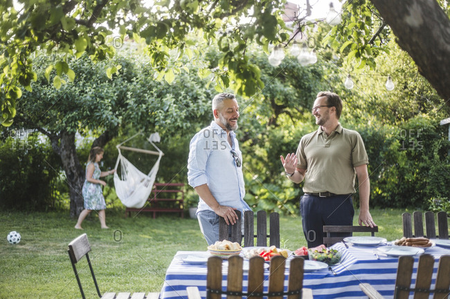 Happy male friends spending weekend together during party in backyard