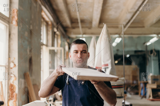 Professional craftsman doing his job in carpentry workshop.