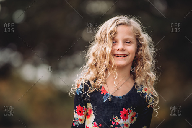 Portrait Of A Happy Blonde Girl With Curly Hair Wearing A Floral Dress Stock Photo Offset