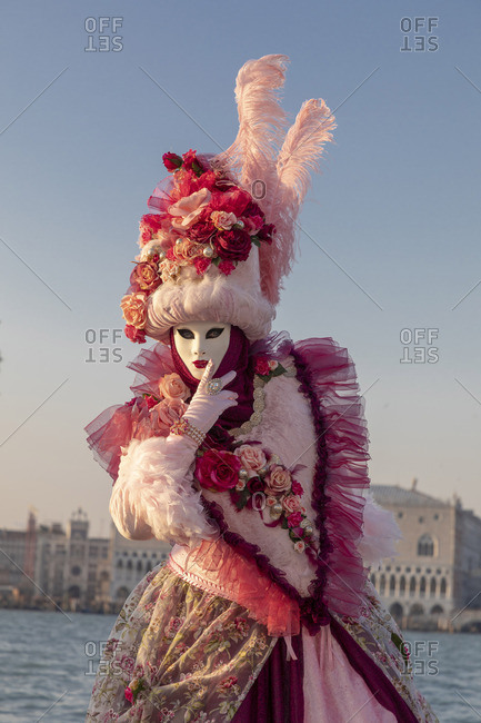 A poseur wearing a colorful pink costume on San Giorgio Maggiore during the Venice Carnival , Venice , Veneto, Italy