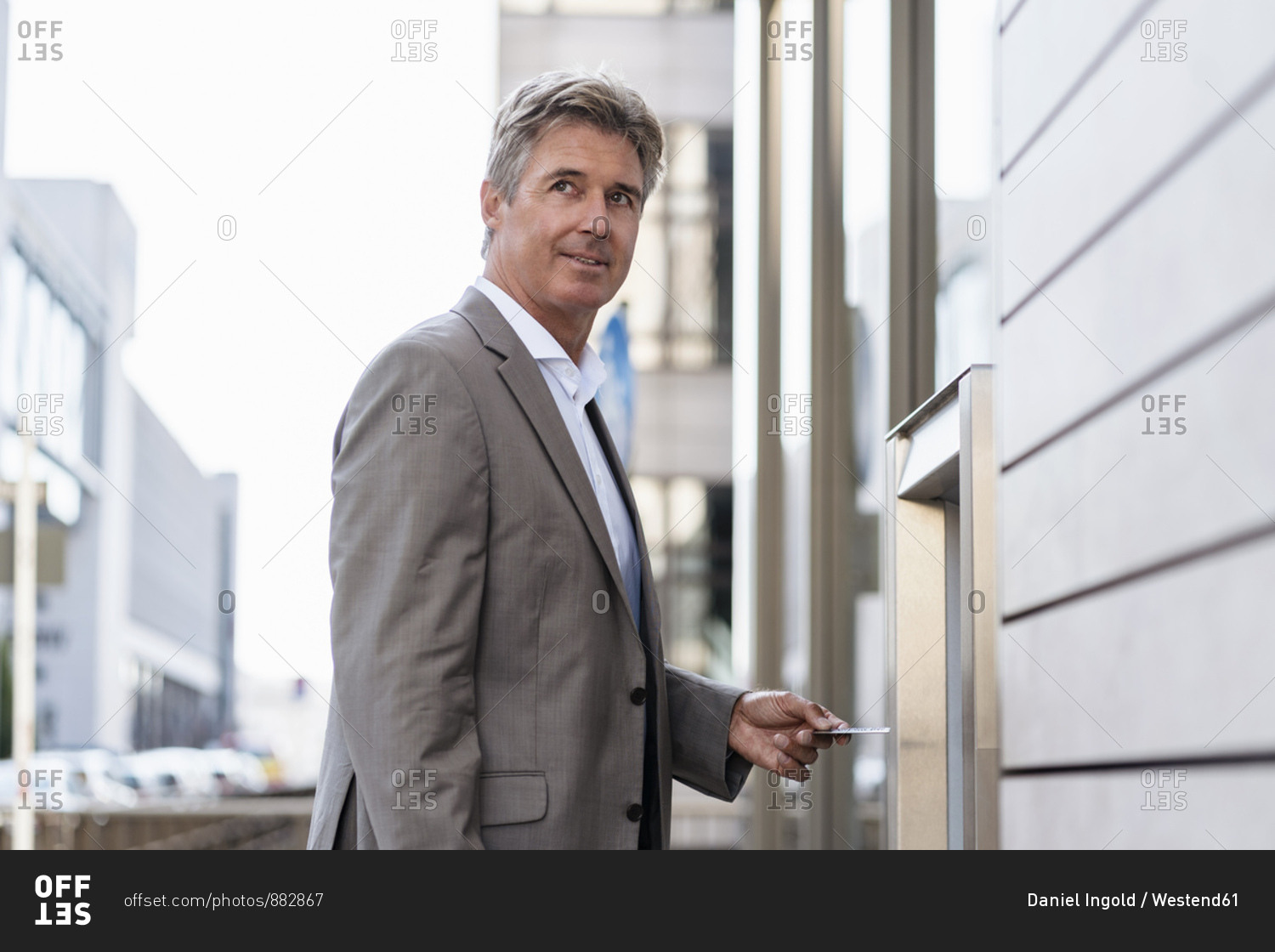Mature businessman withdrawing money at an ATM