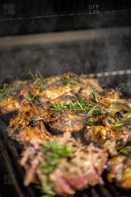 Meat on a grill with rosemary