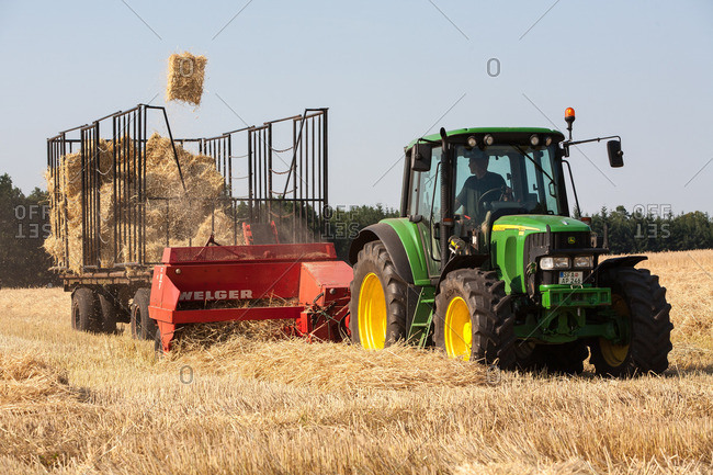 Tractor with straw press and catcher