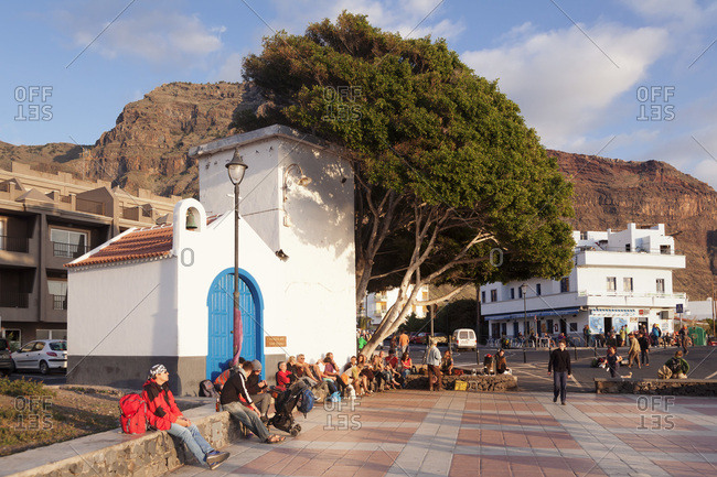 December 29, 2014: Tourists on the market square at sundown, district la playa in valle gran rey, la gomera, canary islands, spain
