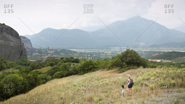 Panoramic picture of the rocky landscape around meteora with woman and child on meadow