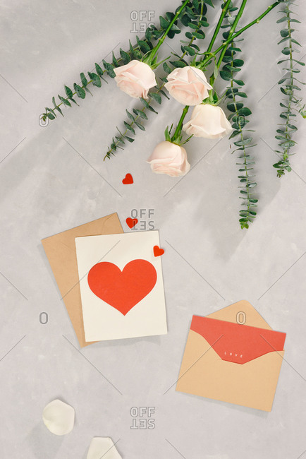 Pink roses bunch with Valentines card on light background. Top view, flat lay