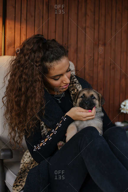 Portrait of a brunette girl cuddling with a puppy