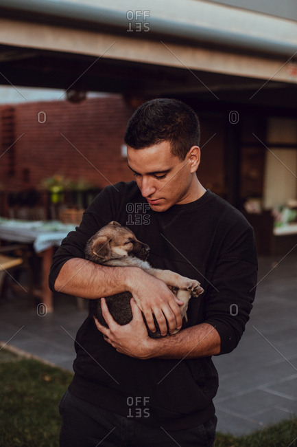 Portrait of a man cuddling with a puppy