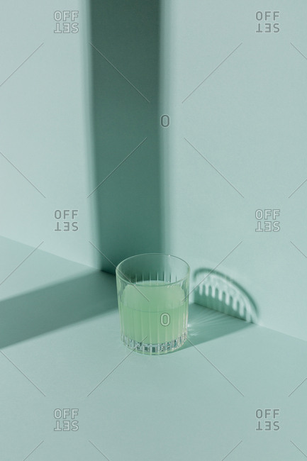 Green cocktail on green background with shadow