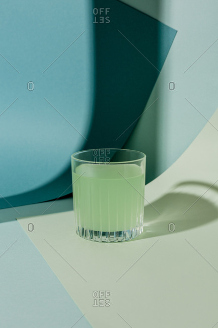 Green cocktail on green and blue paper background