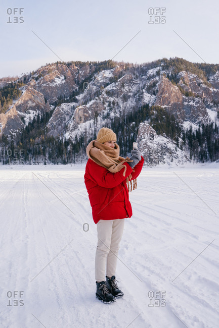 Woman taking picture of snowy mountains with smartphone
